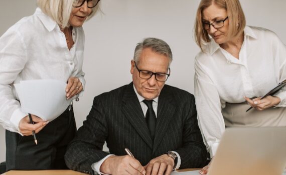 A man and two woman planning and discussing outsourced and in house IT