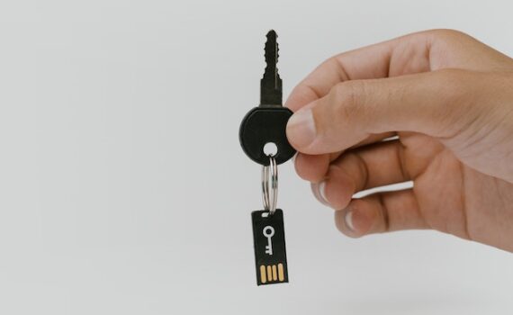 A person holding up a key and micro chip for cyver security