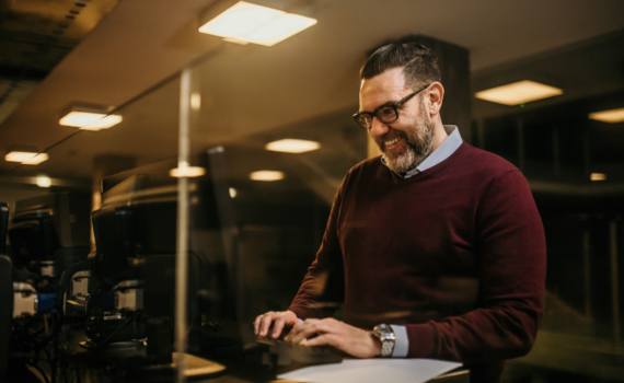 male office worker on desk computer researching tips for relocating office and IT supplies in 2023