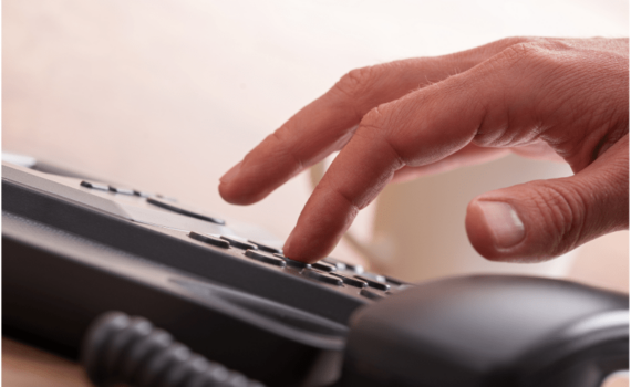 A person dialling a traditional landline phone in a small growing business in the UK before the PSTN and IDSN network switch off