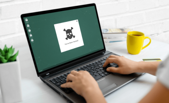 A person typing on a laptop wondering what types of ransomware exist and how they can affect your SME.