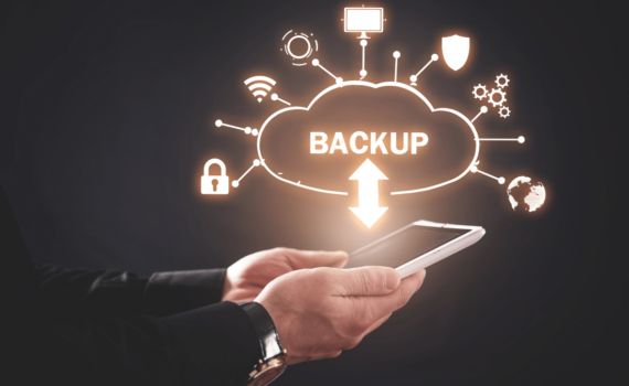 A business owner holding a white tablet in their hands with a white graphic above showing how backing up your data in the cloud protects it.