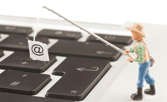 A person with a fishing rod holds the @ sign, representing what phishing emails do.